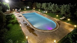 A rectangular swimming pool with a curved edge, surrounded by a paved deck. - Dar izniren (Ourika)