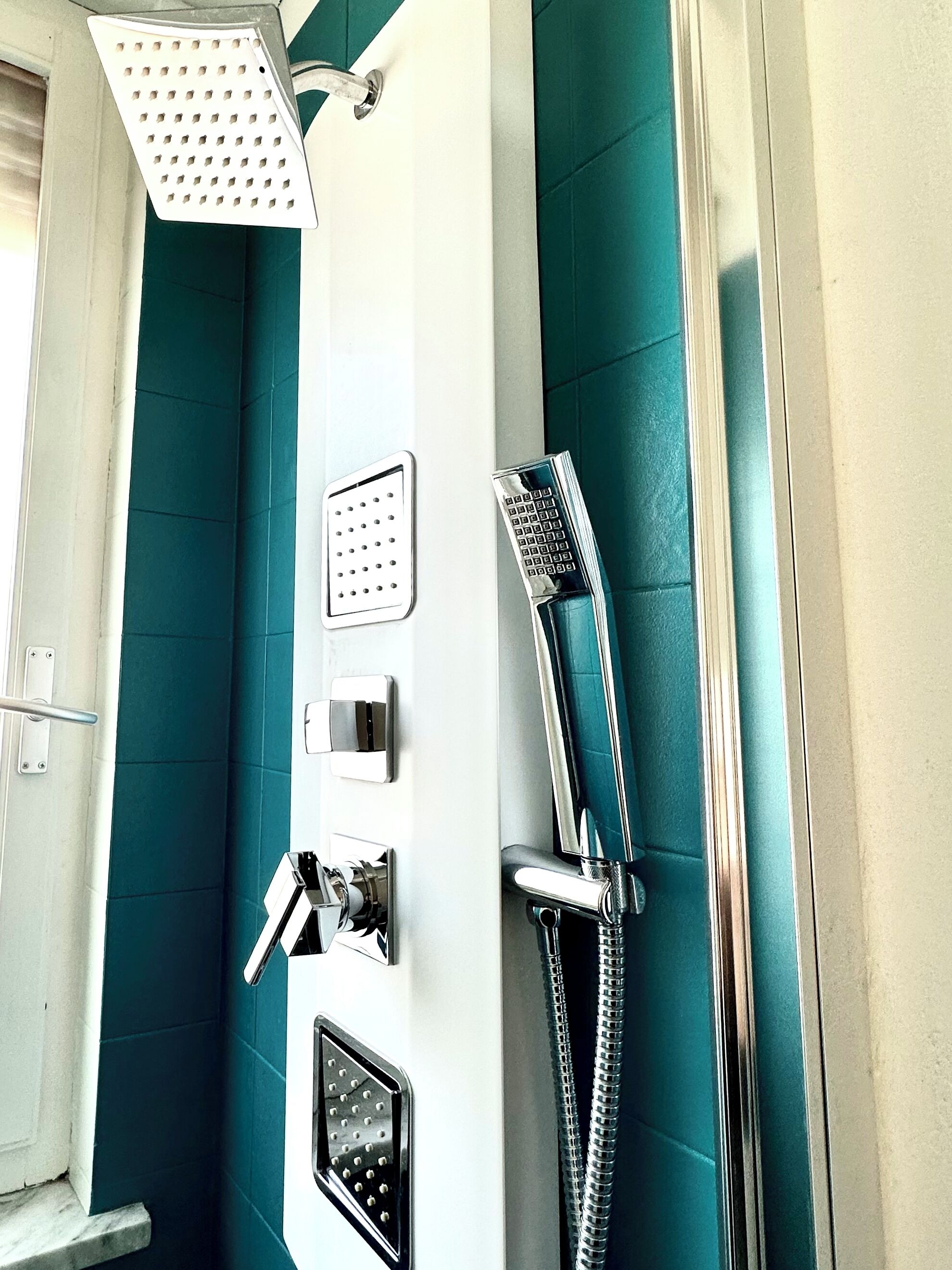 A bathroom with a shower, a towel rack, and a toilet.