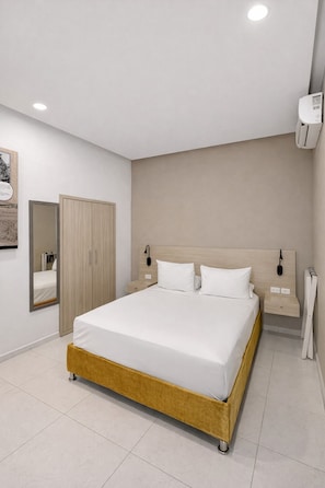 A modern bedroom with a large bed, a wardrobe, a mirror, and a bedside table. - Hotel Gallery Cartagena (Cartagena)