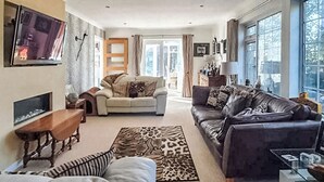Un salon avec une cheminée, un canapé, une table basse et un tapis.