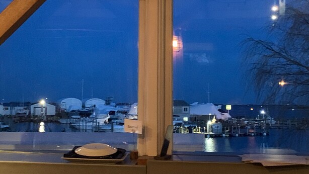 A view from inside a building looking out to a marina with boats and docks. - Perfect Hamptons Family Fall escape (Hampton Bays)
