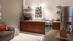Een moderne keuken met houten kastjes, een inbouwoven en een roestvrijstalen koelkast.