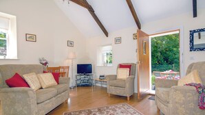 A living room with two sofas, a TV, and a wooden floor. - Lower Bushford Cottage (Hasguard, near Dale)