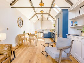 Une cuisine moderne avec un coin repas, un plancher en bois et une lucarne.