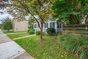 A residential property with a front yard, a house with a porch, and a driveway.
