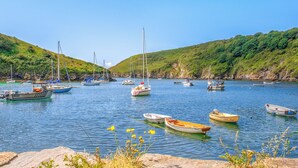 A harbor with various boats, calm water, and green hills in the background. - 3 bedroom accommodation in Druidstone Cross - near Nolton Haven (Haverfordwest)