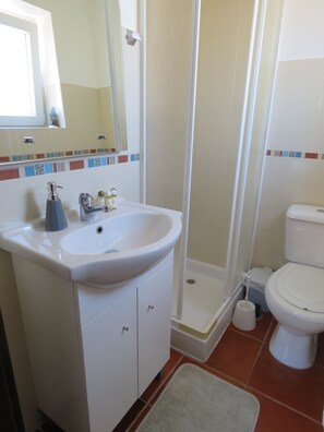A bathroom with a white sink, mirror, and toilet. - Casa Belos Ares (Peniche)