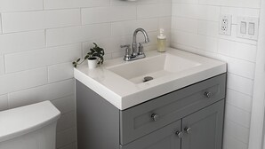 Un bagno con un lavandino bianco, uno specchio, un water e un porta asciugamani.
