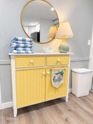 A yellow vanity with a mirror, a lamp, and a towel stack. - Hemingway's Neighbor: Hot Tub, Sundeck, Old Town (Key West)