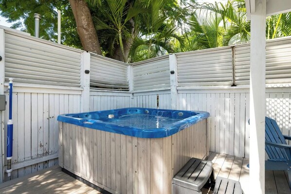 A wooden hot tub with a blue rim, surrounded by a white fence, and a blue chair to the right. - Hemingway's Neighbor: Hot Tub, Sundeck, Old Town (Key West)