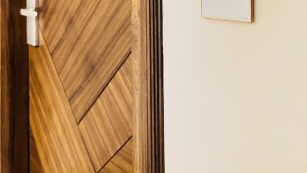 A wooden door with a modern lock and a wall-mounted control panel displaying the number 101. - The Prime Delhi (New Delhi)