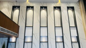 A modern interior with marble-patterned walls, recessed lighting, and a ventilation system. - The Prime Delhi (New Delhi)
