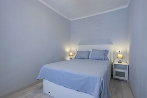 A bedroom with a bed, two bedside tables with lamps, and a nightstand. - House with 1 bedroom, 1 bathroom and terrace near the sea (Can Picafort)
