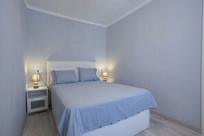 Un dormitori amb un llit, dues taules de nit i dues làmpades.