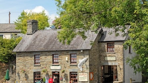 A stone building with a sign for 'The Salmon Leap' offering tea, coffee, and snacks. - Spacious Teifi Valley barn for holidays near the Cardigan coast. (Cenarth)