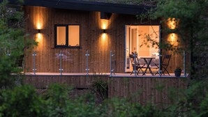 A wooden cabin with a dining area and a small table with chairs.