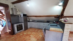 A kitchen with a tiled floor, a built-in oven, a refrigerator, and a sink.