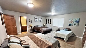 A bedroom with two beds, a door, and wall decorations.
