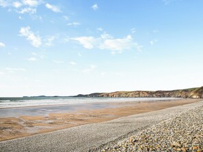A beach with pebbles, a sandy shore, and distant cliffs. - 3 bedroom accommodation in Solva (Solva)