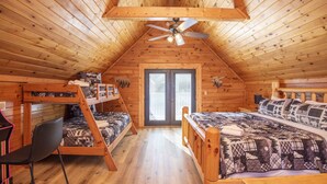 A wooden cabin bedroom with bunk beds, a ceiling fan, and a large window. - 3 Kings / Deck / Fireplace / 100Mbps / Games Games/ Parking/ Dollywood 5mi (Sevierville)