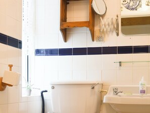 Ein Badezimmer mit Toilette, Waschbecken und Spiegel.
