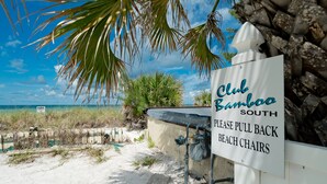 A beachside sign for Club Bamboo South with a clear view of the ocean and beach vegetation. - Amazing View, Updated Beachfront Condo (Bradenton Beach)