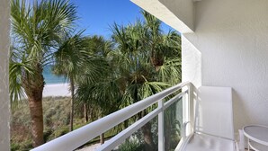 A balcony with a view of palm trees and a beach. - Updated Beachfront Condo at Prestigious Long Boat Key Resort (Longboat Key)