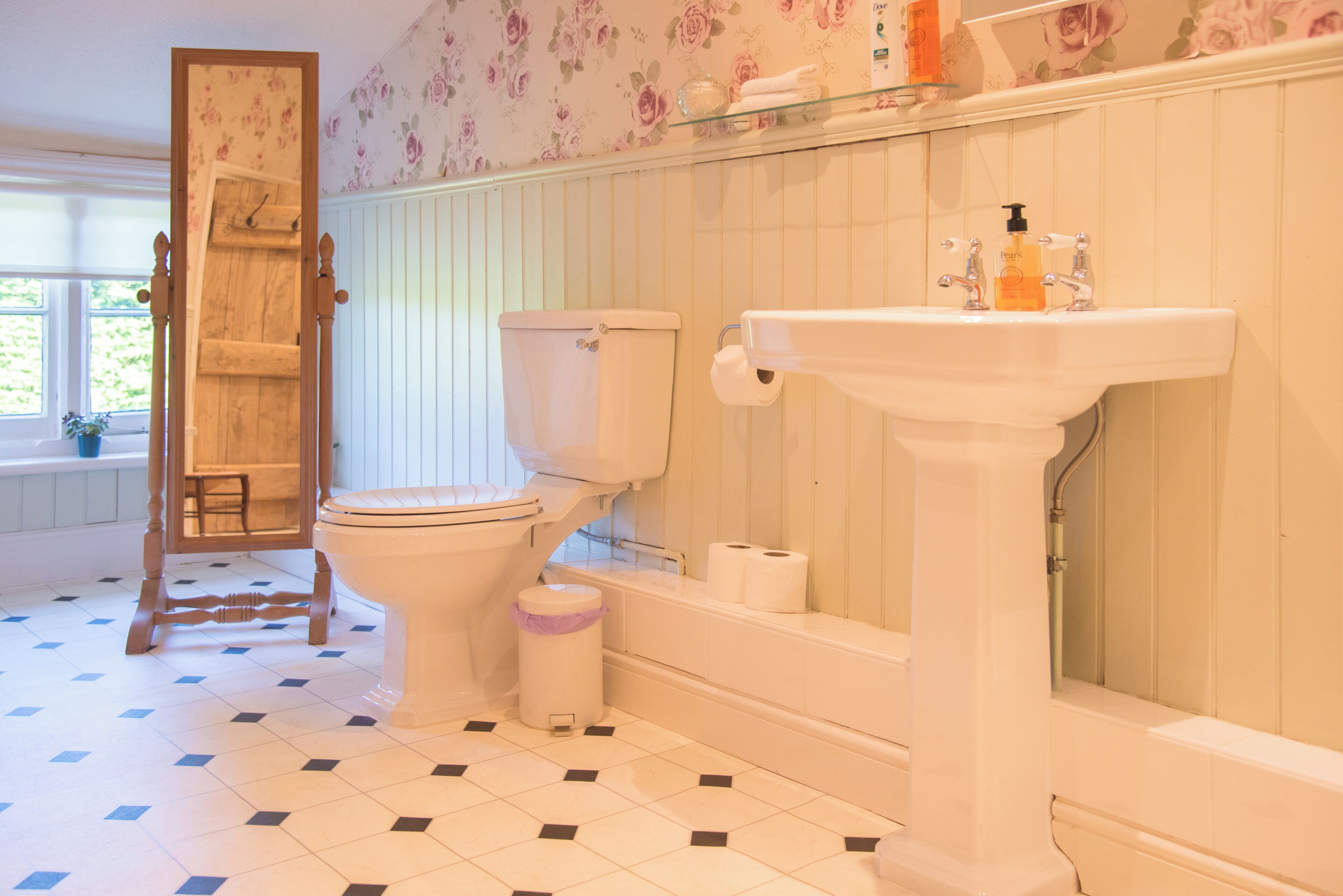A bathroom with a toilet, sink, and shower.