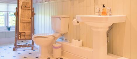 A bathroom with a toilet, sink, and shower.