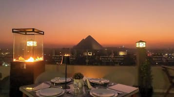 A table set for dining with a view of a pyramid and hotel signage in the background.