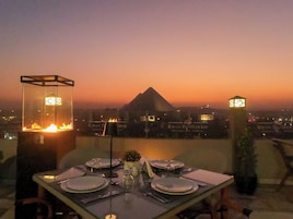 A table set for dining with a view of a pyramid and hotel signage in the background.