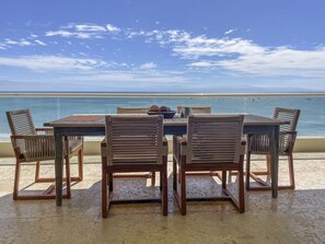 Enjoy a serene ocean view from this terrace with a table and four chairs.