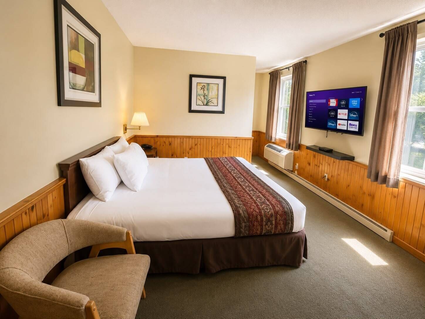 Een hotelkamer met een bed, een stoel, een televisie en een raam.