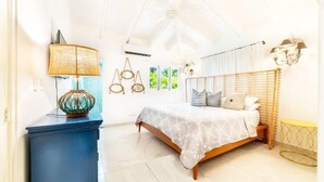 Un dormitorio con una cama, un aparador azul, una lámpara y una ventana con cortinas.