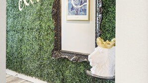 Une pièce avec un mur vert, une carte encadrée et une chaise blanche.