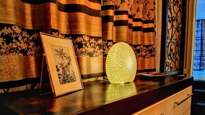 A room with a dark wooden dresser, a framed picture, and a decorative light on the dresser. - Super spacious (Quatre Bornes)