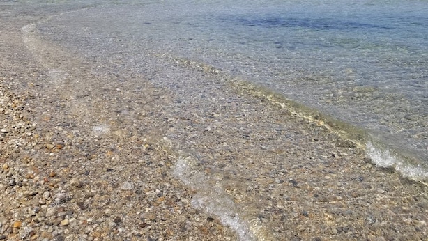A clear beach with pebbles and a forested mountain in the background. - Private mountain view haven in the beautiful West Kootenays (Kaslo)