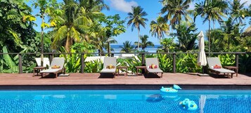 Una piscina al aire libre, sillones reclinables de piscina
