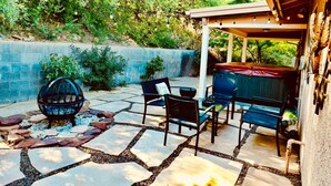 An outdoor patio with stone flooring, a fire pit, and outdoor furniture.