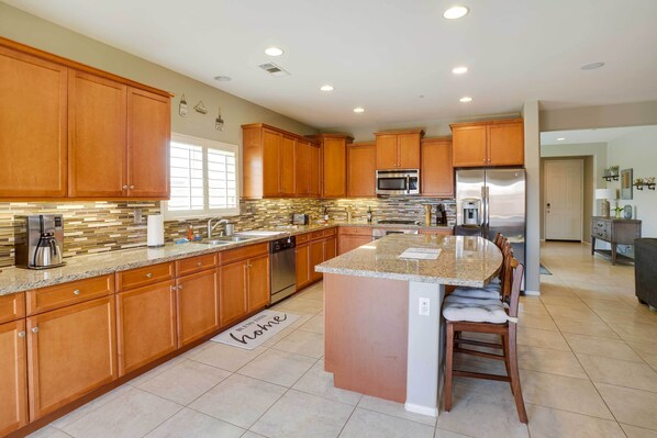 Enjoy cooking in this well-equipped kitchen with a central island, stainless steel appliances, and ample counter space.