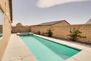 Relax by the rectangular pool surrounded by a tiled deck and lush greenery.