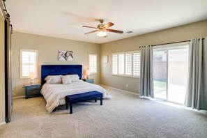Relax in this serene bedroom with a large bed, ceiling fan, and two bedside tables with lamps.