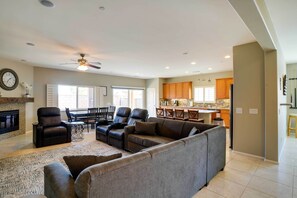 Relax in the living room with a large sofa and two recliner chairs, perfect for unwinding in front of the fireplace.