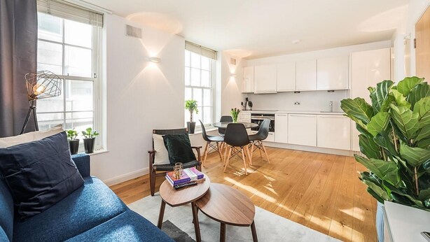 Een modern appartement met een zithoek, eethoek en keuken.