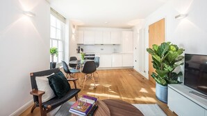 Een modern appartement met een zithoek, eethoek en keuken.