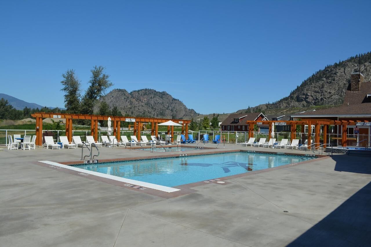 A pool area with lounge chairs and a pergola structure.