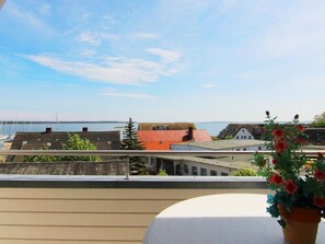 A balcony with a view of buildings and a body of water.