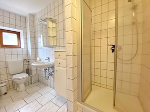 A bathroom with a toilet, sink, and shower.
