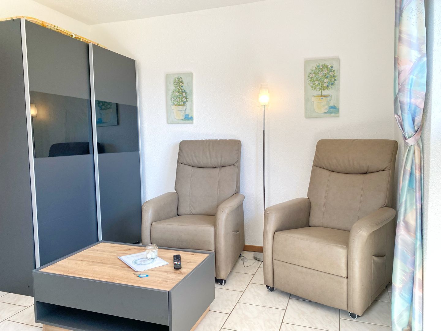 Ein modernes Zimmer mit einer Couch, zwei Sesseln, einem Couchtisch und einer Stehlampe.