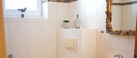A small bathroom with a toilet, sink, and a window.
